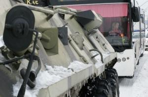 Бронетранспортеры тянут машины в Киеве из-под снега