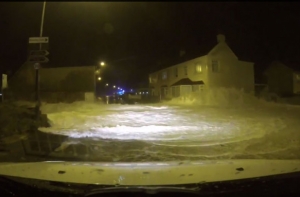 Волна смыла с дороги женщину-полицейского (ВИДЕО)