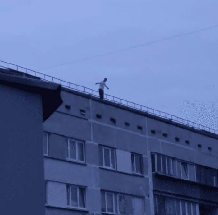 Опасные игры! Подростки залезли на крышу многоэтажного дома в Пурвциемсе. Один из них свисал вниз