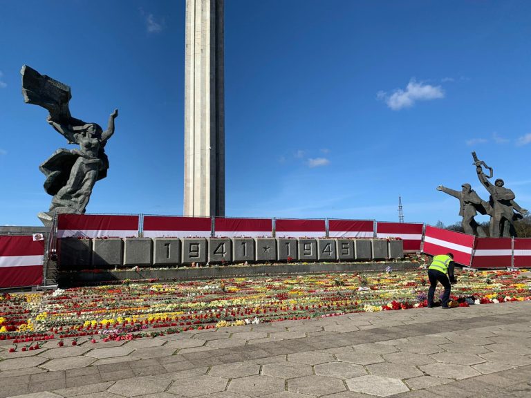 Люди возлагают цветы к памятнику в Пардаугаве: один человек задержан