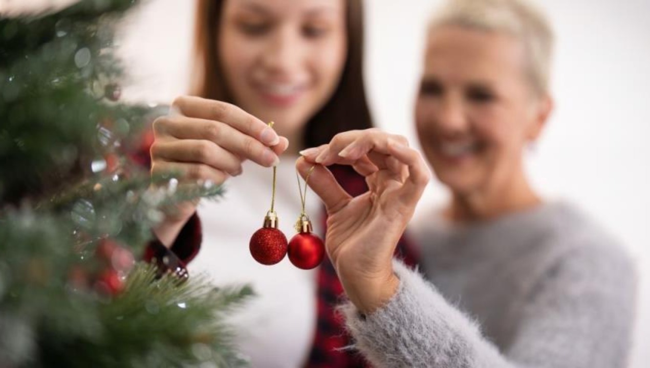 Девушка у новогодней ёлки в уютной домашней атмосфере - символ спокойного и осознанного начала года.