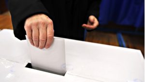 Избиратель опускает бюллетень в урну на президентских выборах в Португалии в Лиссабоне