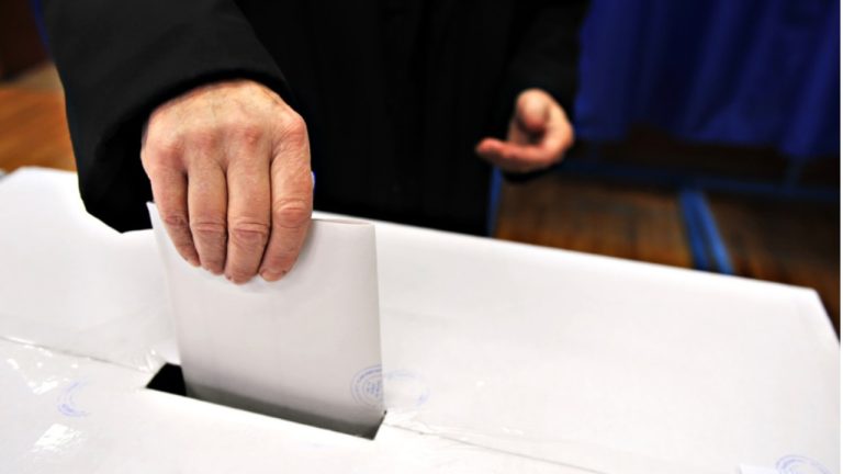 Избиратель опускает бюллетень в урну на президентских выборах в Португалии в Лиссабоне