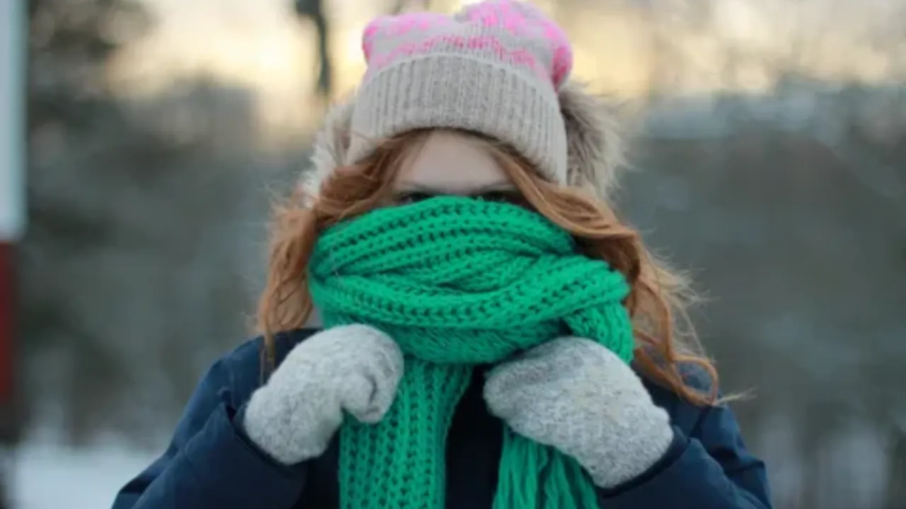 Девушка гуляет зимой в шарфе и шапке - иллюстрация к статье о том, как зимние аксессуары могут вызывать раздражение и прыщи на коже лица