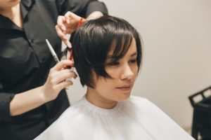 Парикмахер делает короткую стрижку «воздушный пикси» — модный тренд 2026 года для тонких волос после 50