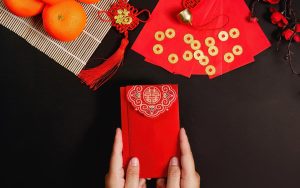 Украшения и символы Лунного Нового года — красные конверты, фонари и фрукты как знак удачи и процветания.