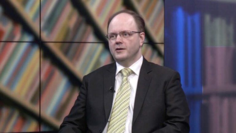 Илмарс Пойканс обсуждает пенсионный кризис в Латвии: график демографической ямы и пенсионной системы первого уровня, иллюстрирующий снижение числа работающих и угрозу будущим выплатам.