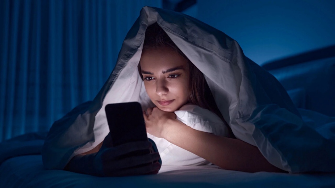 Смартфон с открытым Instagram в тёмной комнате ночью — символ проверки страницы бывшего.