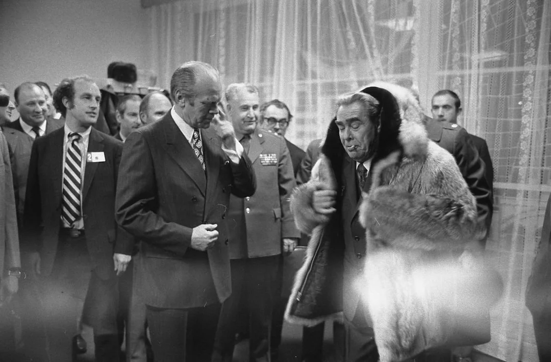 Президент США Джеральд Форд позволяет Леониду Брежневу примерить своё пальто - необычный дипломатический момент холодной войны, 1974 год.