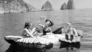 Три молодые женщины едят спагетти на надувных матрасах на острове Капри, Италия, 1939 год — редкий архивный снимок повседневной жизни XX века.