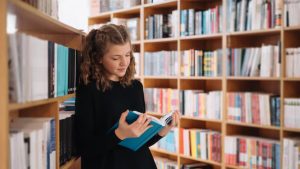 Человек читает книгу в тишине; уютный книжный магазин; стопка книг и чашка чая