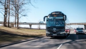 Автобус междугороднего сообщения на трассе Тарту–Рига на фоне дороги и природы