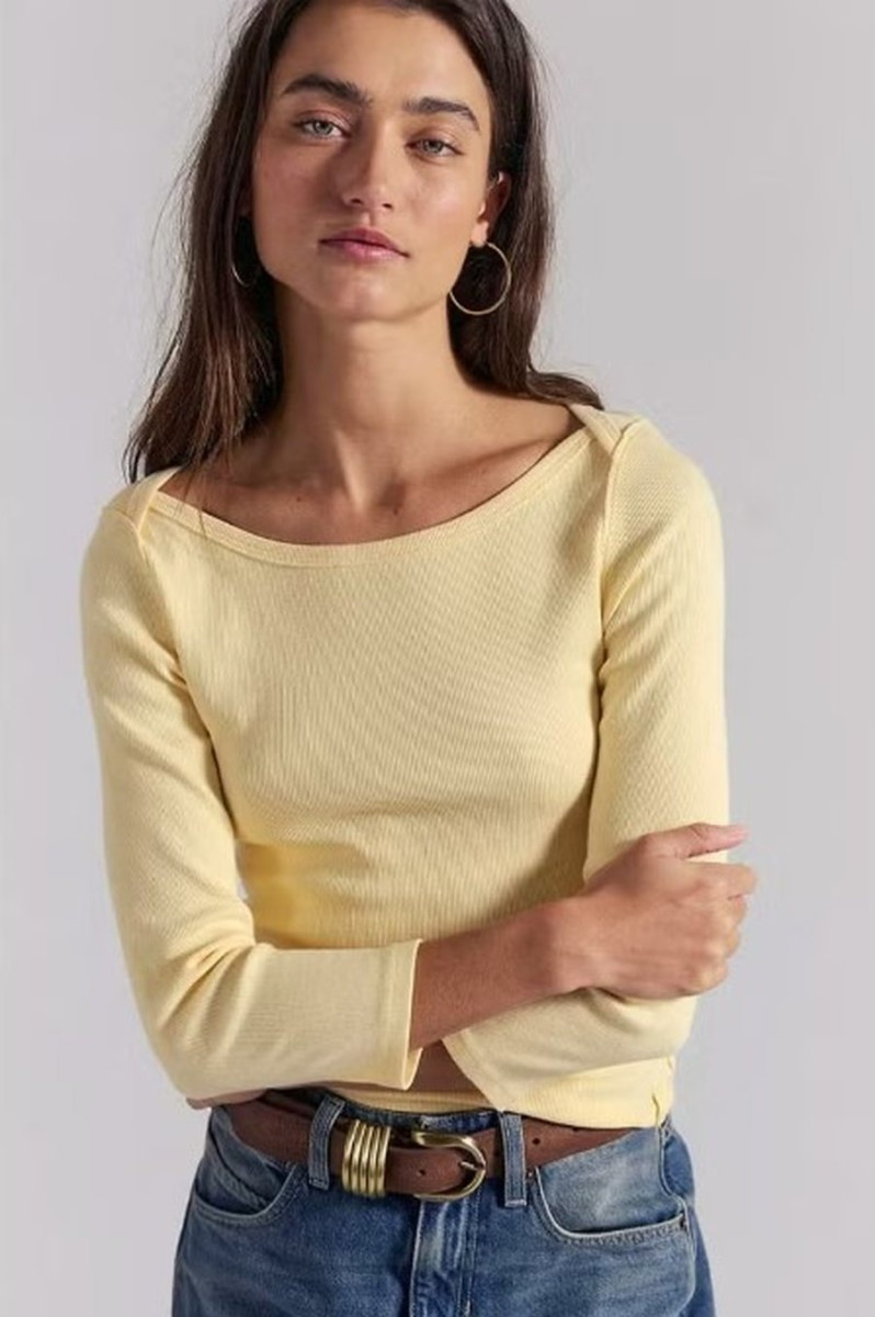 Женщина в минималистичном образе в блузе с рукавом три четверти, весенний стиль в духе 90-х с элегантным силуэтом