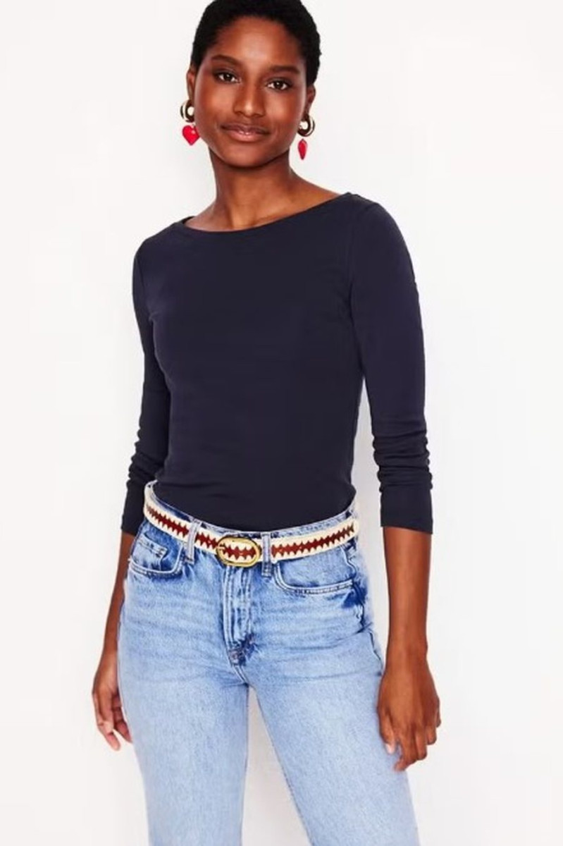 Женщина в минималистичном образе в блузе с рукавом три четверти, весенний стиль в духе 90-х с элегантным силуэтом