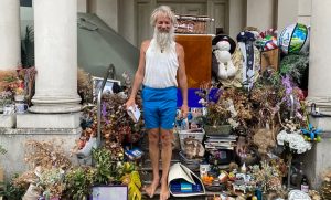 Бездомный мужчина у входа в роскошный особняк в Лондоне с дорогими вещами и одеждой